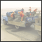 Chinese workers shoving gravel from a truck on the road side for fixing the tar road in the middle of the Takla Makan dessert. Xinjiang, CHN