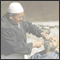 Hairdresser shaves the beard of a man at open-air sunday bazaar. Kashgar, Xinjiang, CHN