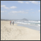 Beautiful big bay. Sky with cumulus plus the sea with white waves and two walkers on the beach Can Picafort, Mallorca, ESPSP